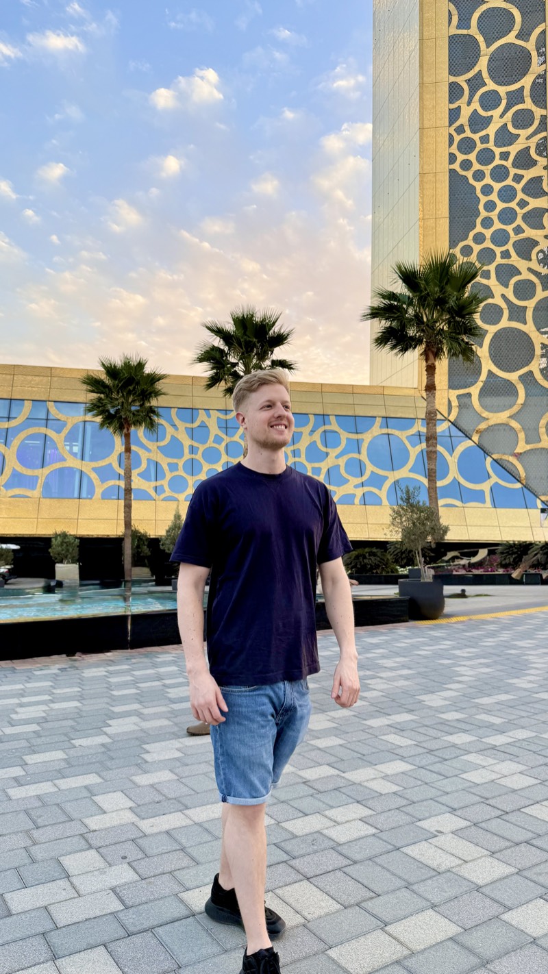 Master Nico walking outside a modern gold and blue building in Dubai